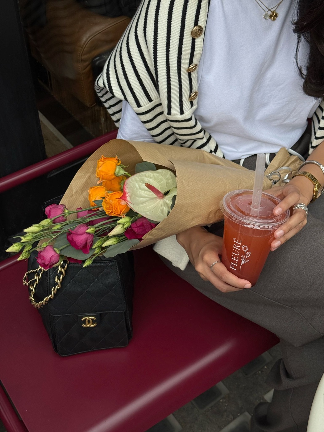 A Fleurè bouquet in one hand and a signature drink in the other